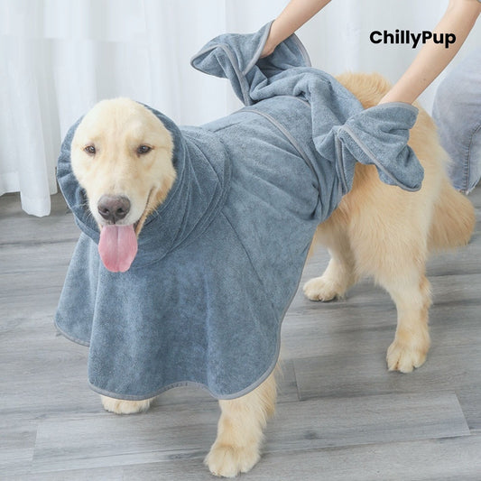 Dog wearing a grey towel with 'ChillyPup' branding, standing on a wooden floor.