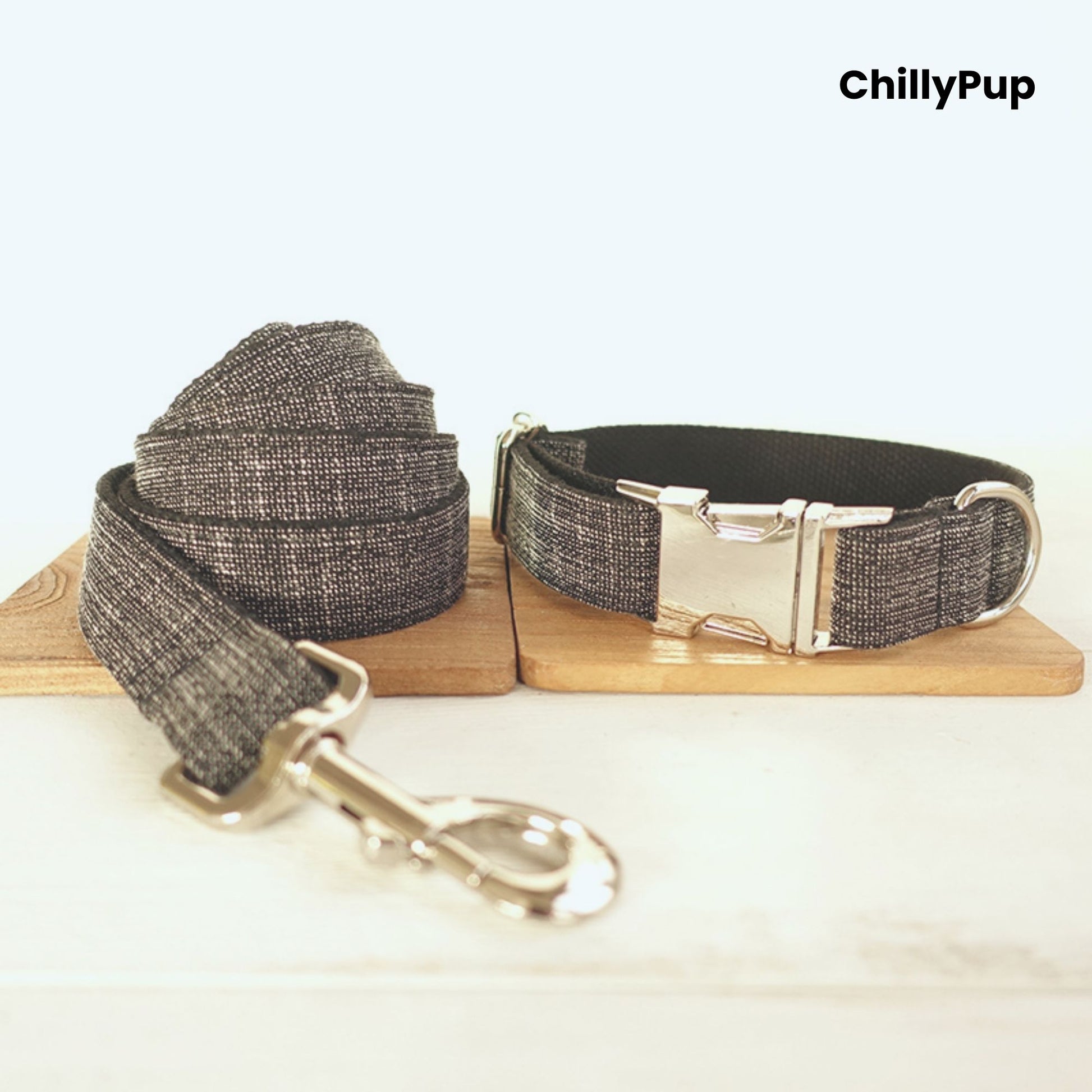 Grey dog collar and lead set with metal clip on a wooden board, branded 'ChillyPup'.