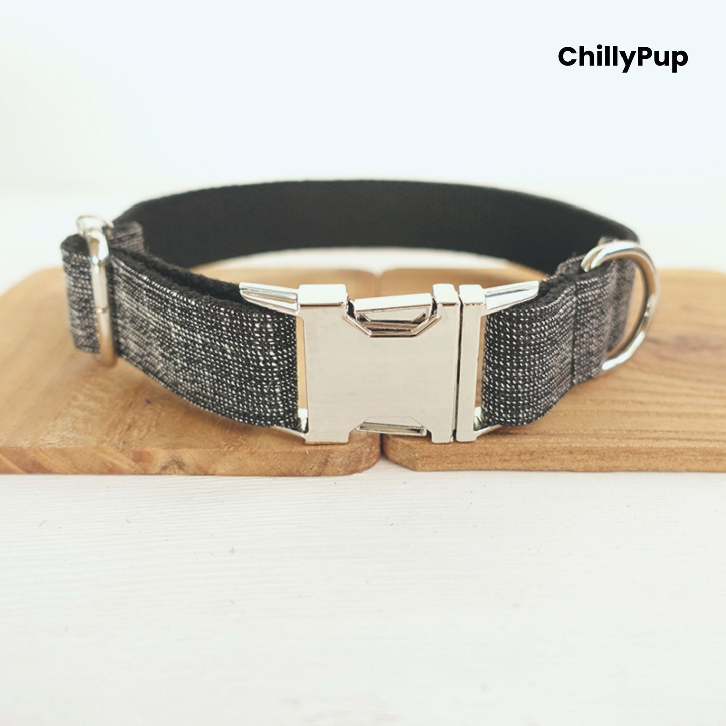 Grey dog collar with metal clip on a wooden board, branded 'ChillyPup'.
