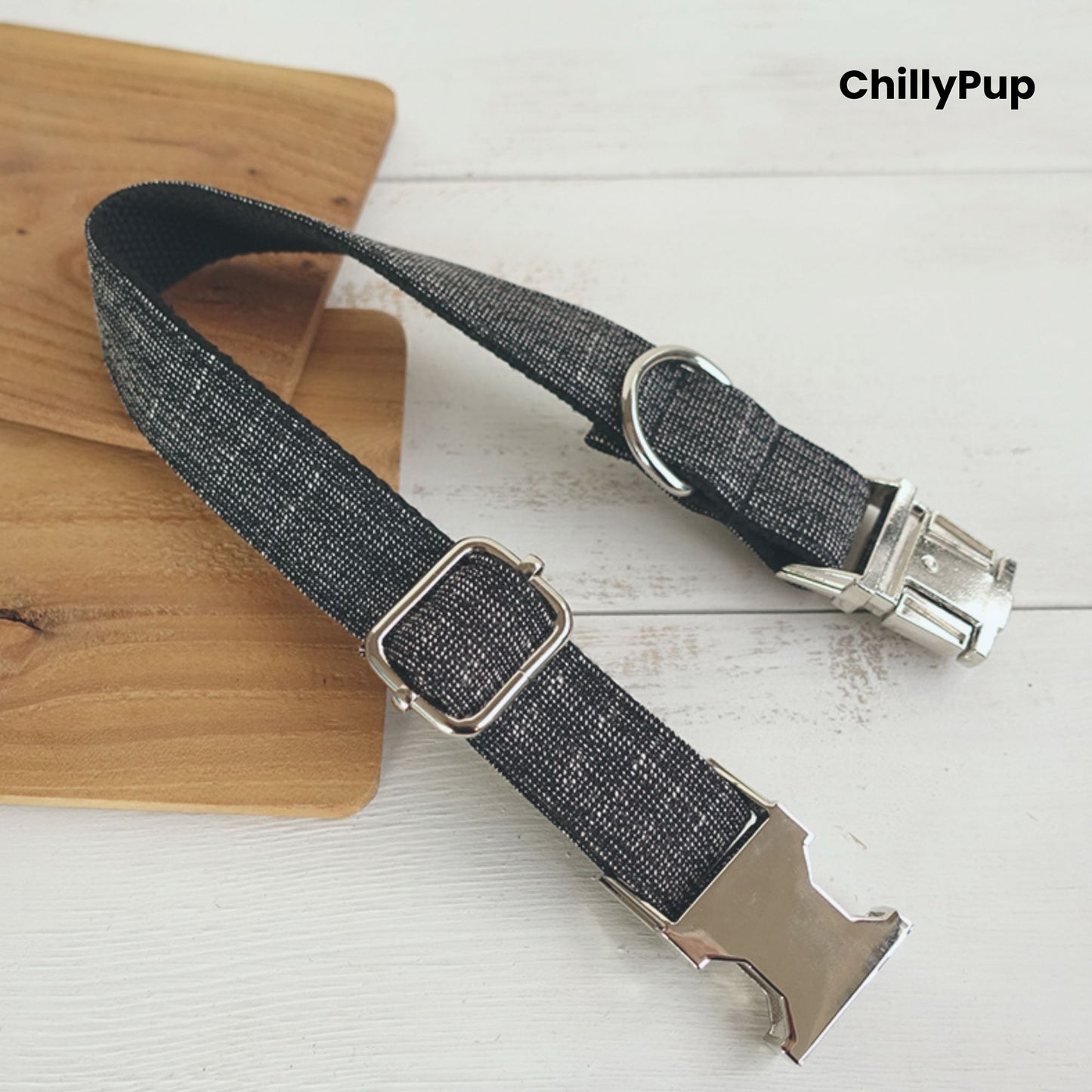 Grey dog collar with metal clip on a wooden board, branded 'ChillyPup'.