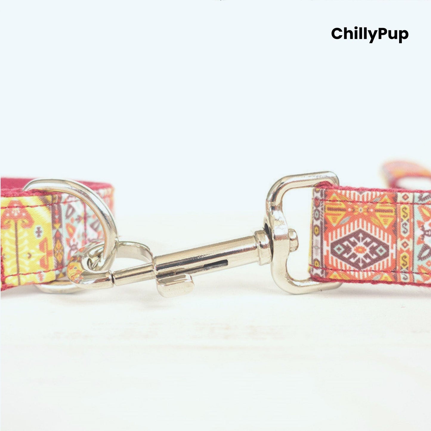Dog collar with colourful pattern and metallic clasp on a white background, branded 'ChillyPup'.