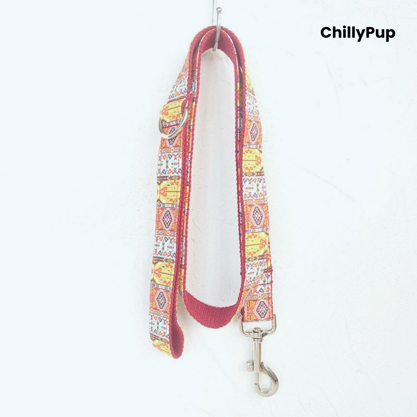 Dog collar with colourful pattern and metallic clasp on a white background, branded 'ChillyPup'.