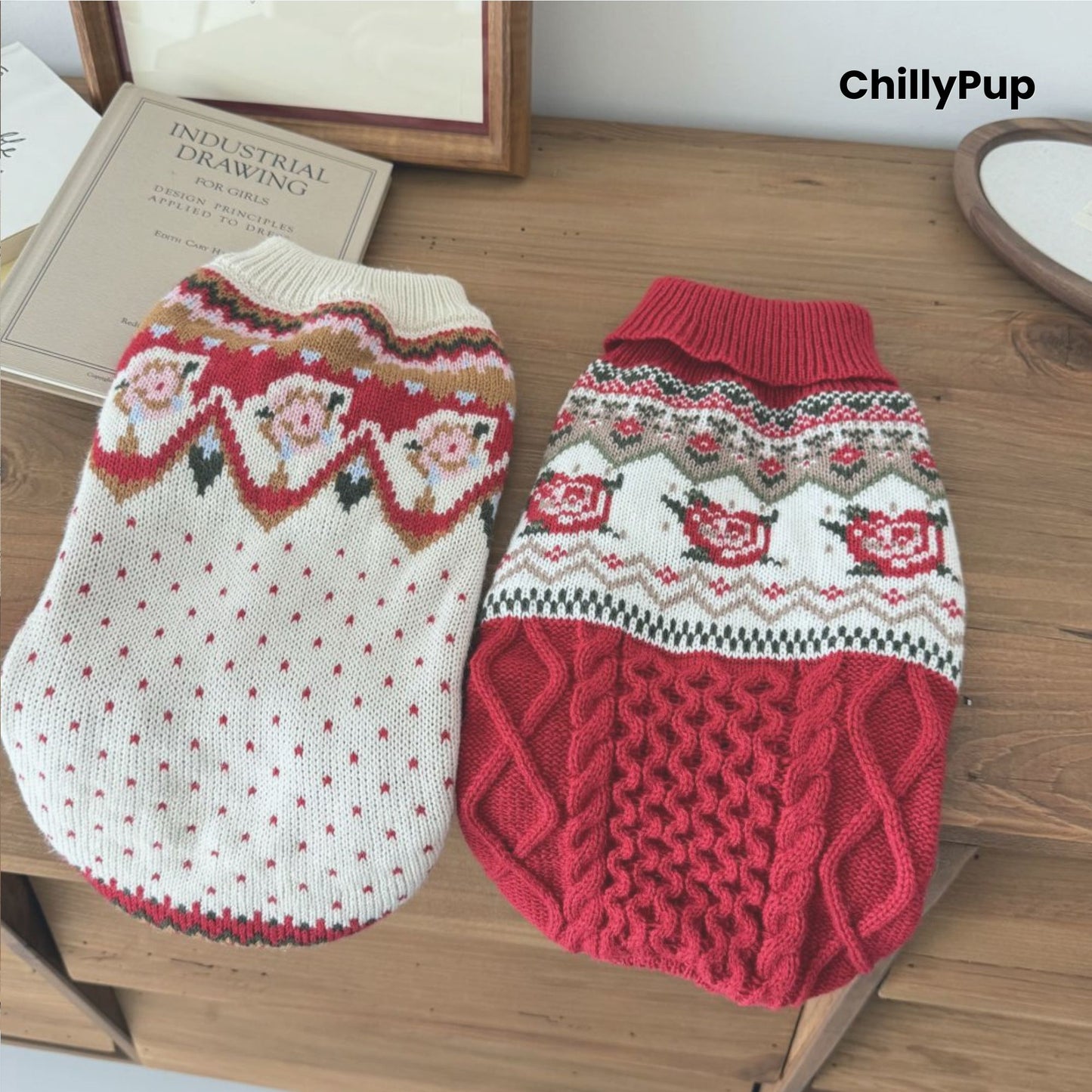 Knitted dog jumpers, one white and one red with patterns, on a wooden surface with 'ChillyPup' branding.