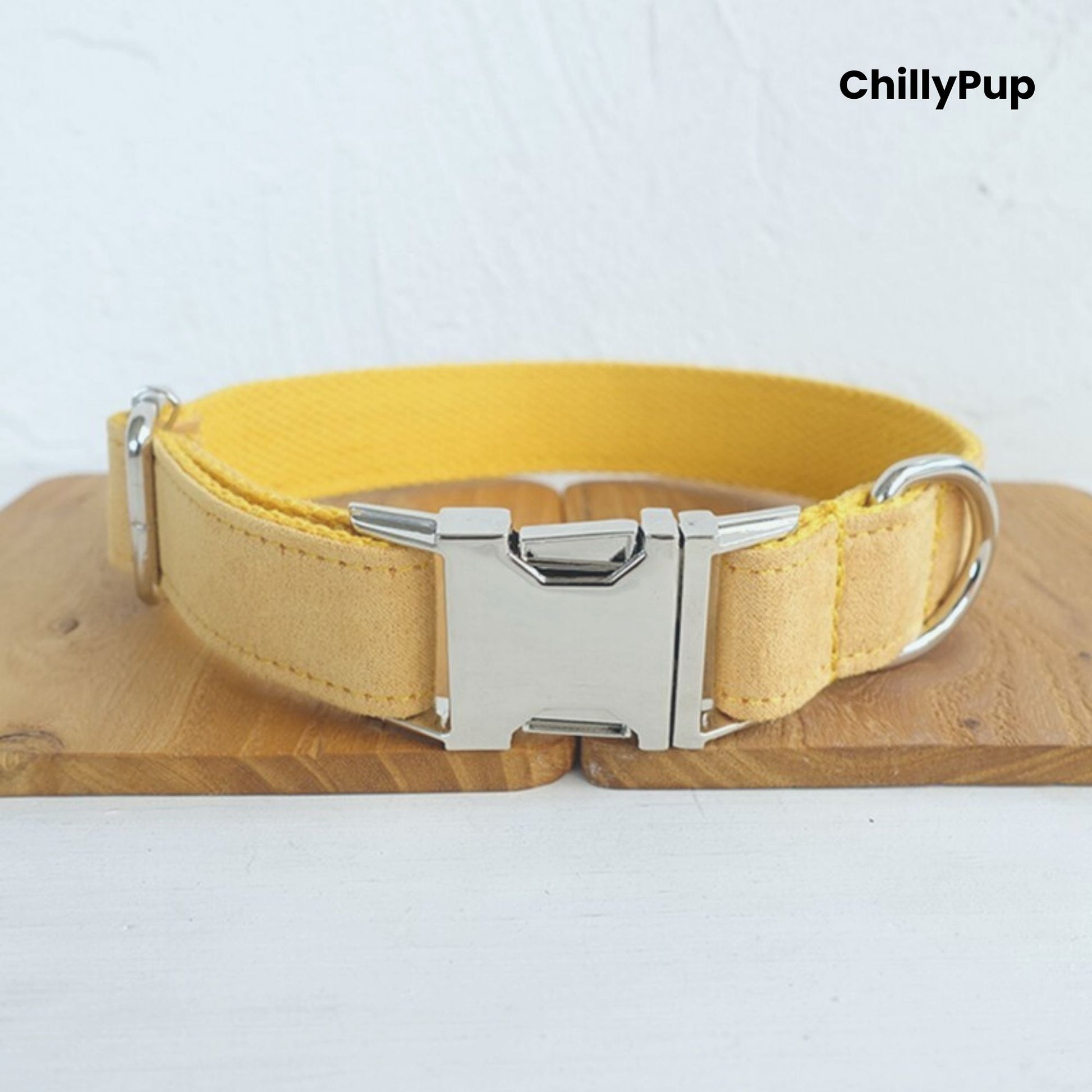 Dog collar with metal buckle on a light wooden surface, branded 'ChillyPup'.