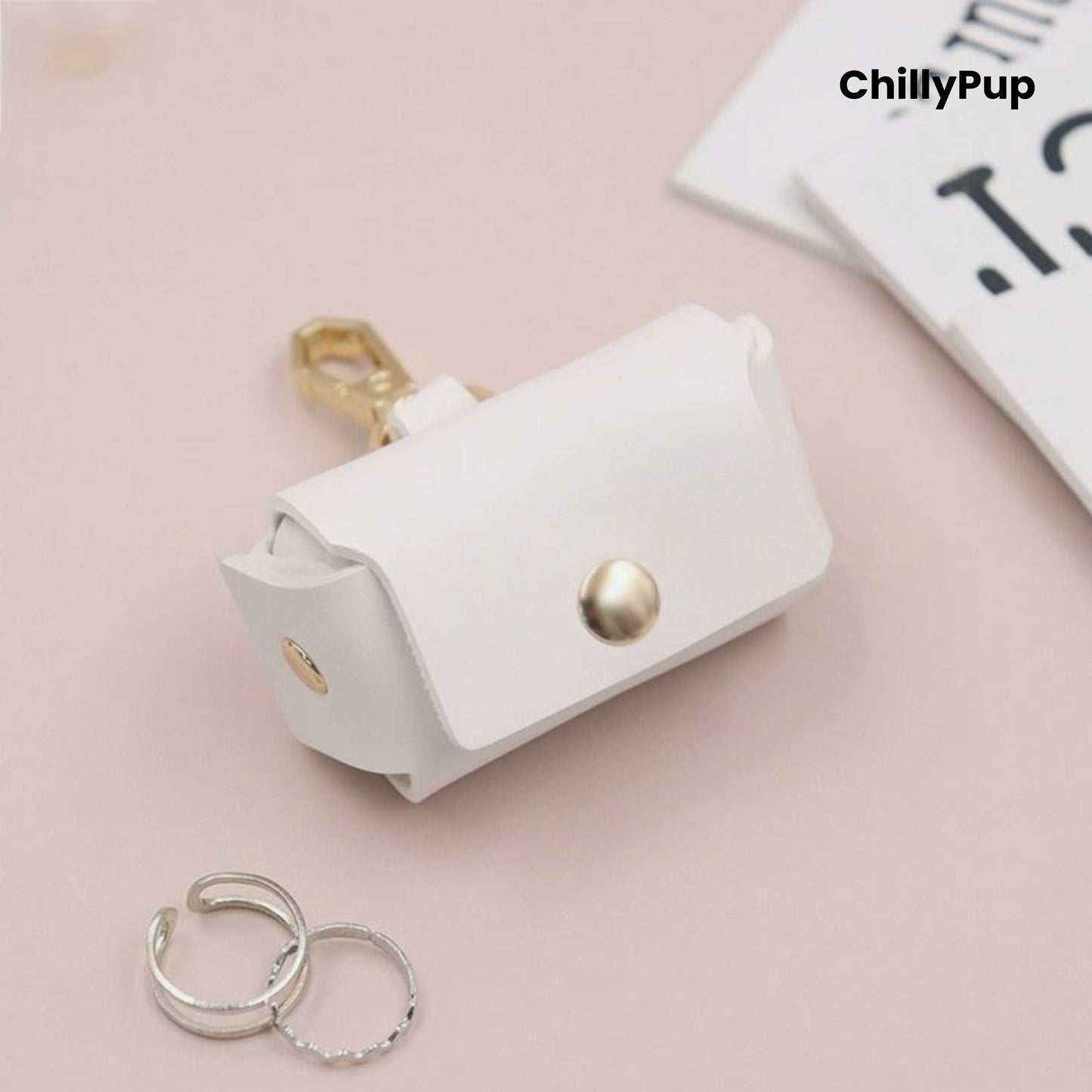 White leather ring pouch with gold accents on a light pink background, featuring the brand 'ChillyPup'.