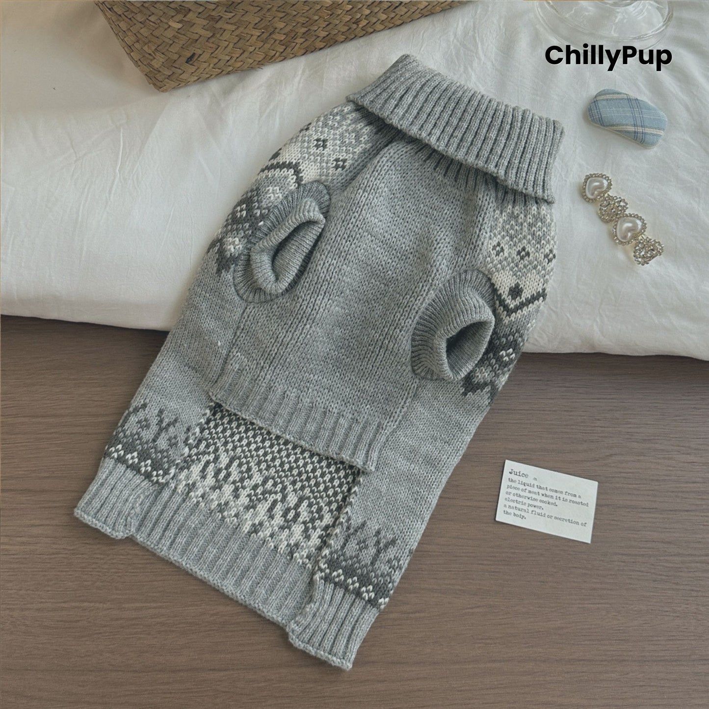 Gray knitted dog sweater with a pattern on a wooden surface, branded 'ChillyPup'.