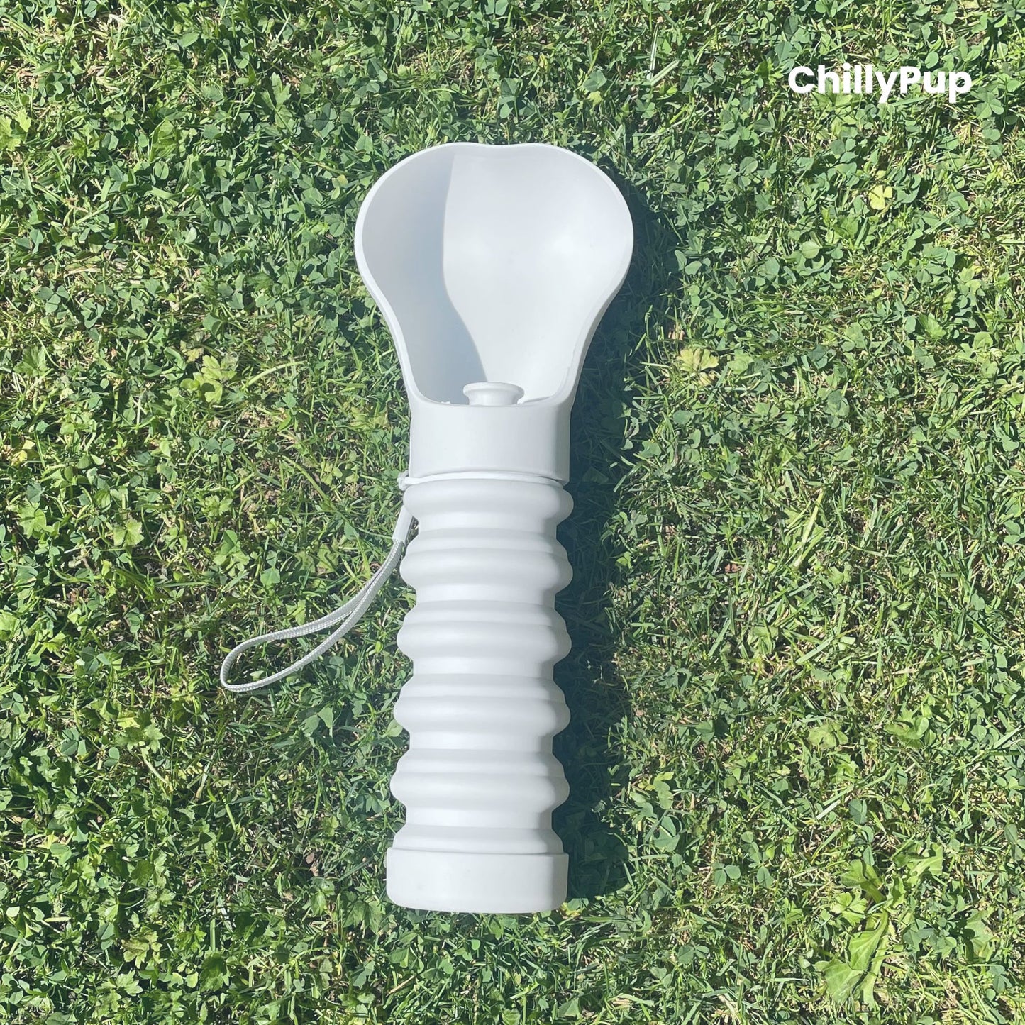 One foldable silicone water bottle with drinking section on grass.