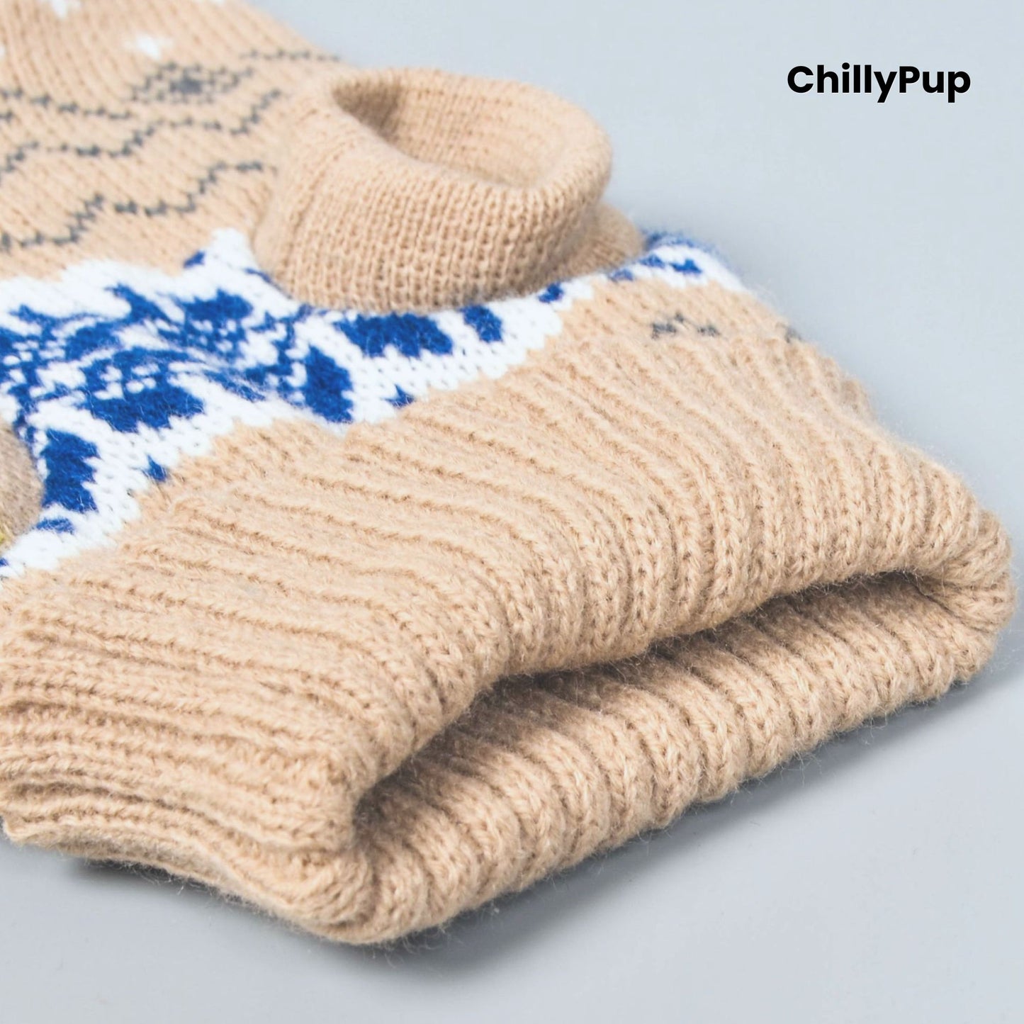Folded beige knitted dog jumper with blue and white pattern on a light grey background, branded 'ChillyPup'.