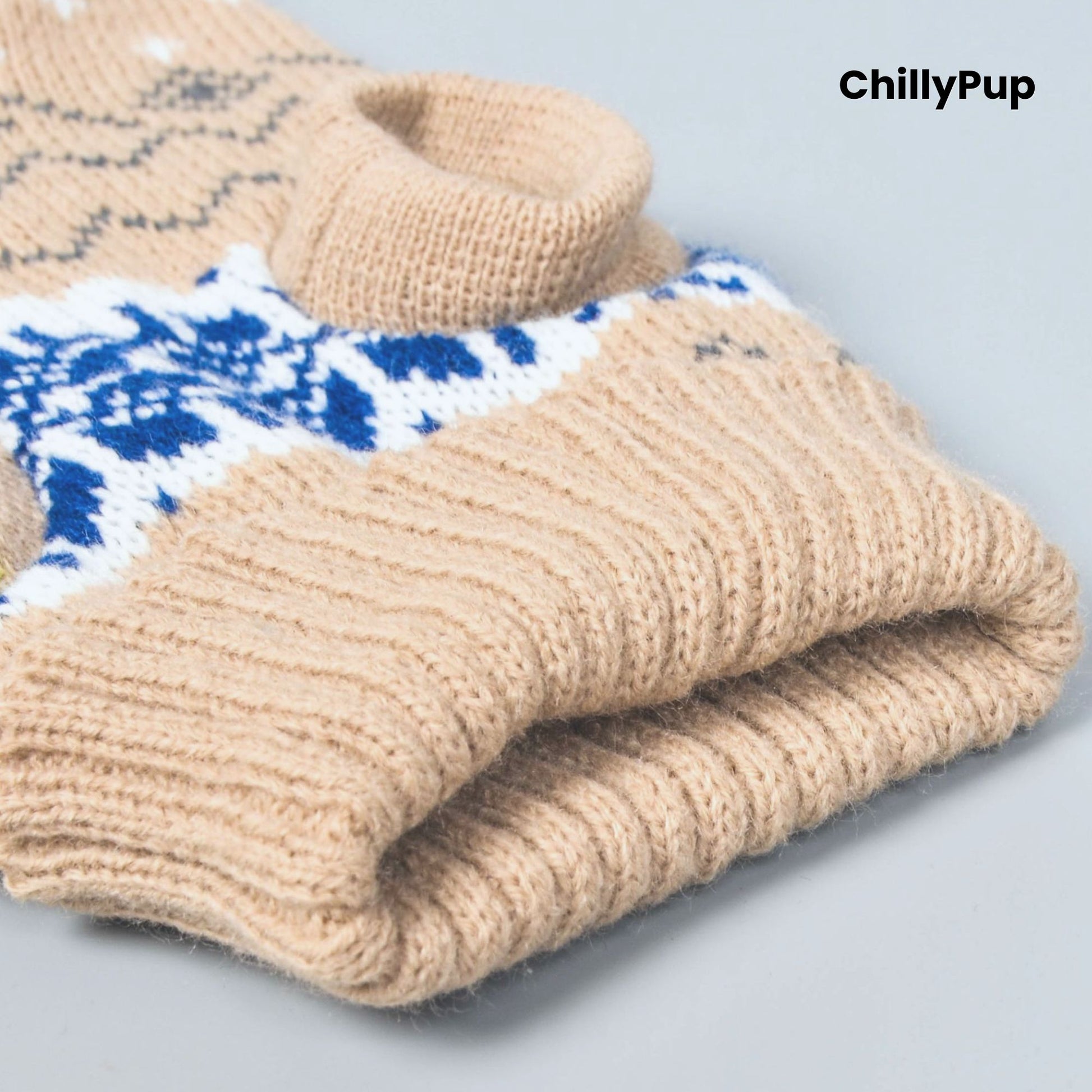 Folded beige knitted dog jumper with blue and white pattern on a light grey background, branded 'ChillyPup'.