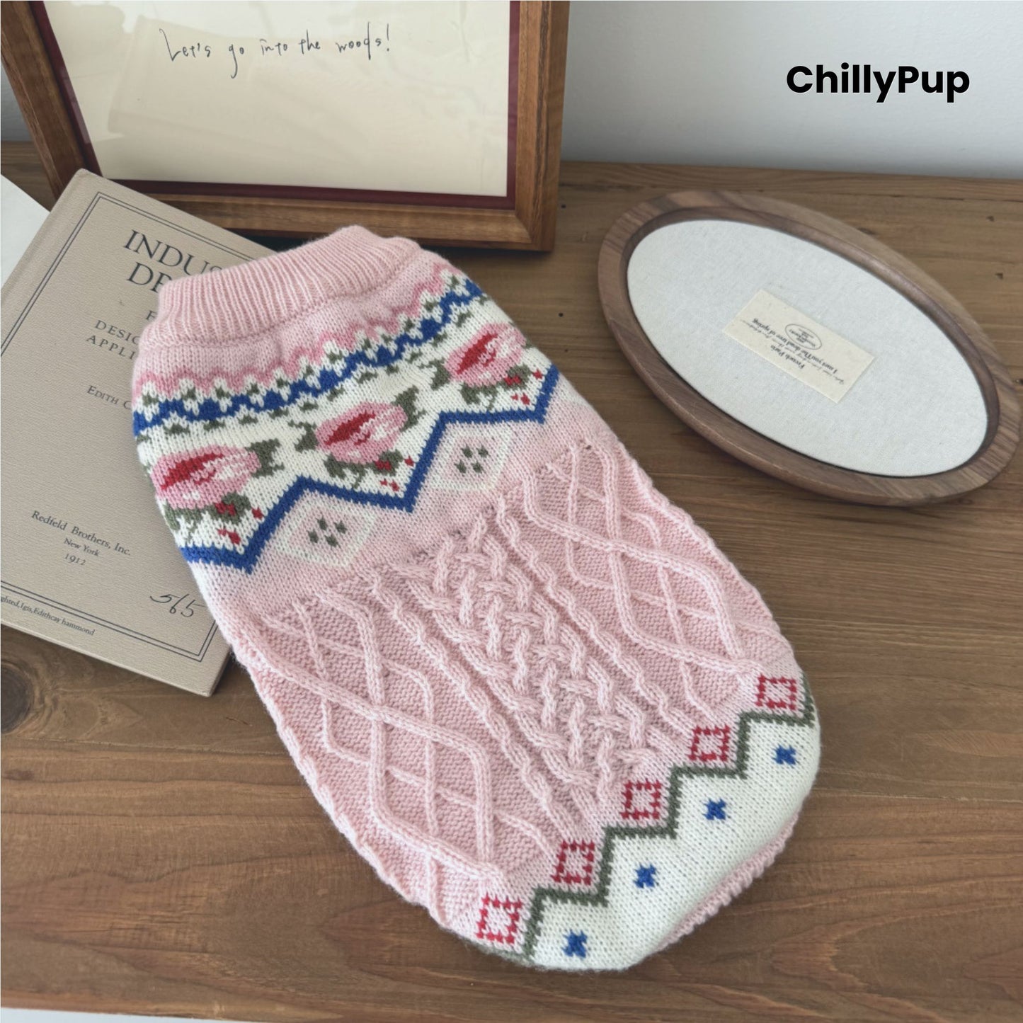 Knitted dog jumper, pink on a wooden surface with 'ChillyPup' branding.