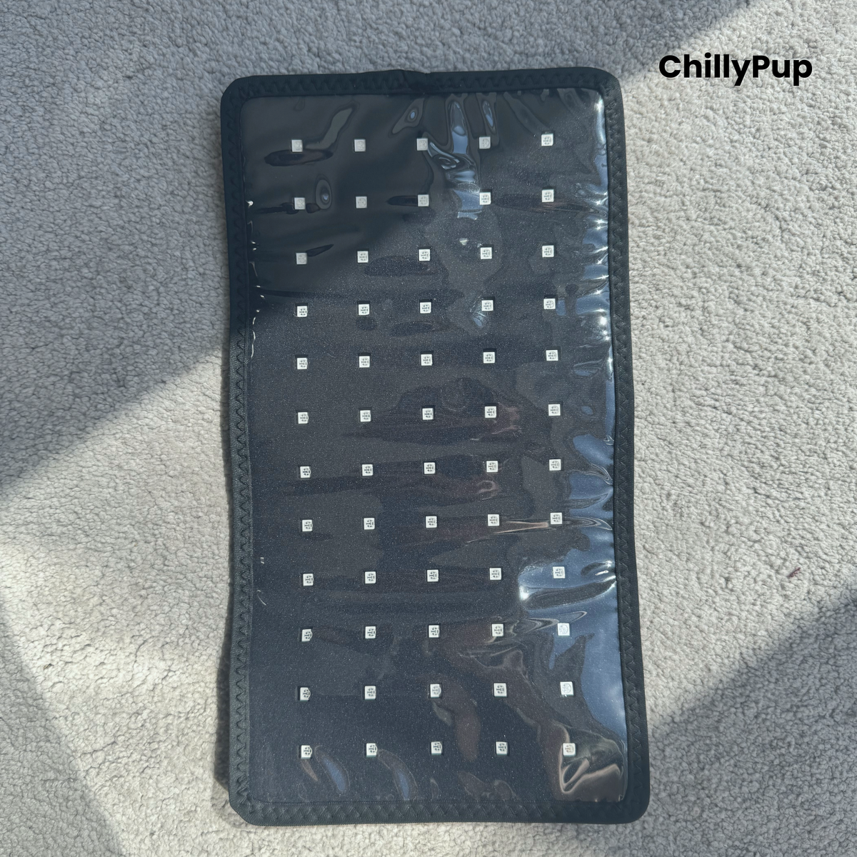 A black Redlight pad with a clear plastic cover and rows of small white LED's, laid flat on a grey textured carpet. The brand name 'ChillyPup' is visible in the top right corner.
