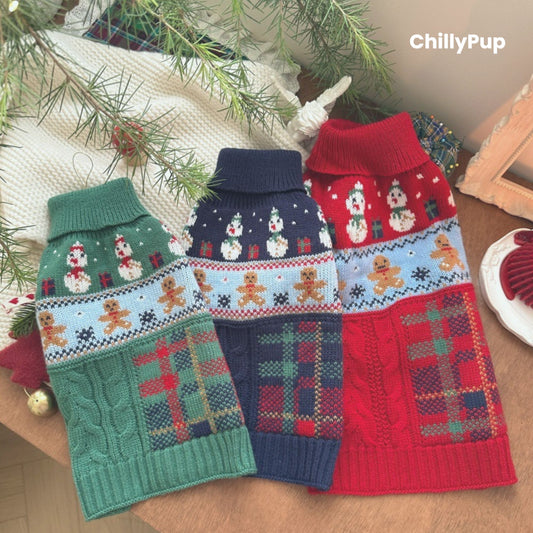 Knitted dog sweater with Christmas design on a wooden surface, surrounded by festive decor. branded with ChillyPup.