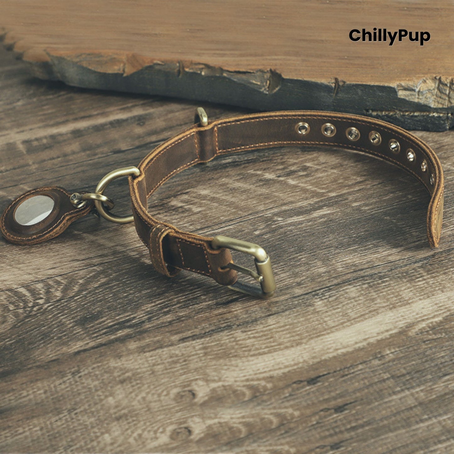 Brown leather dog collar with brass hardware on a wooden surface, branded 'ChillyPup'.