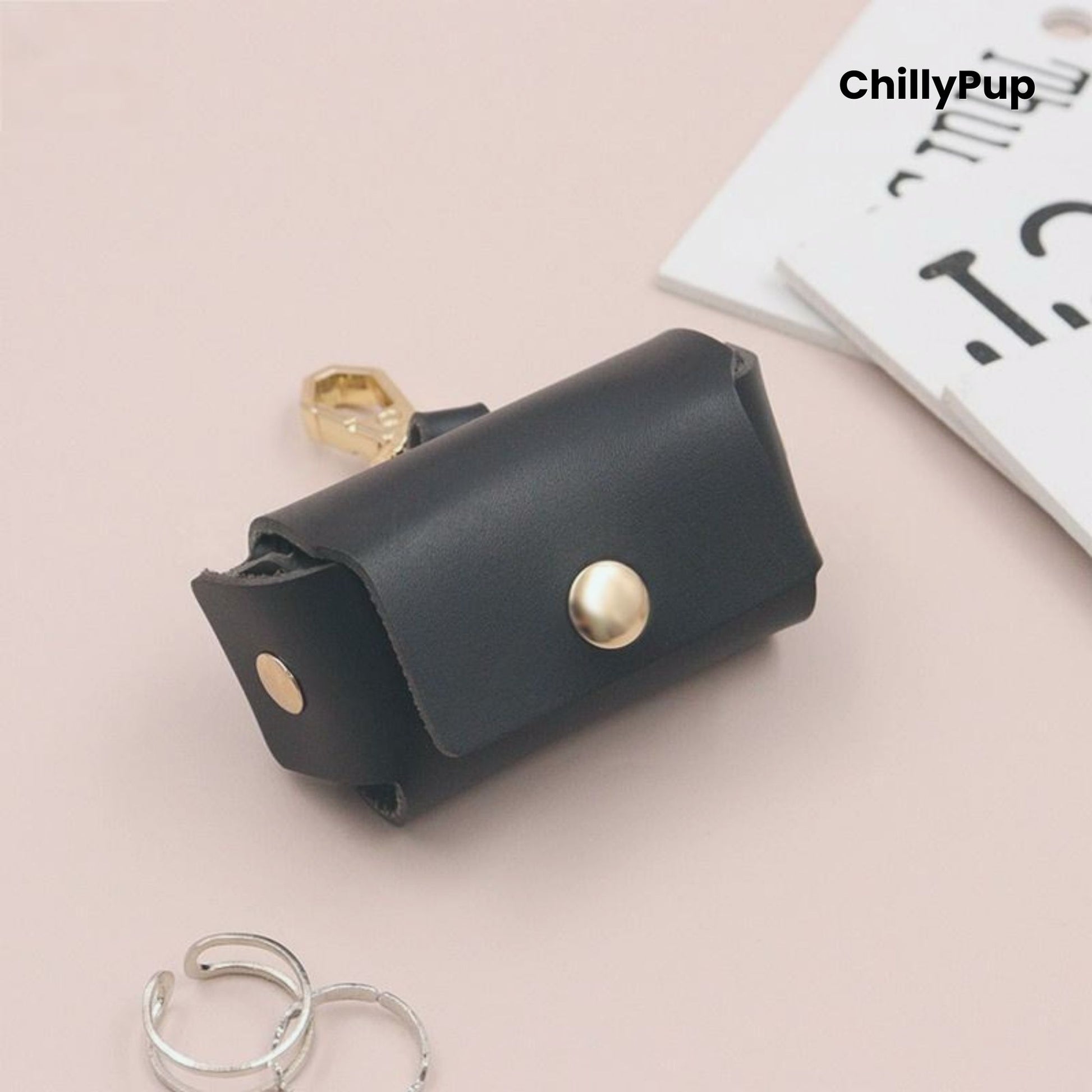 Black leather ring pouch with gold accents on a light pink background, featuring the brand 'ChillyPup'.