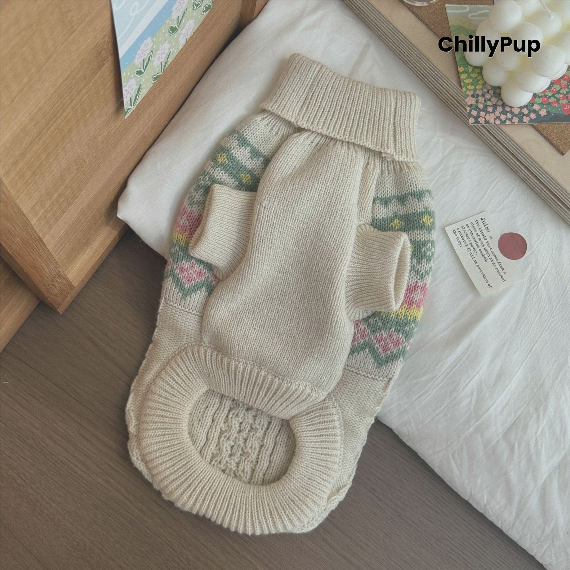 Knitted dog sweater with floral patterns on a wooden surface, branded 'ChillyPup'.