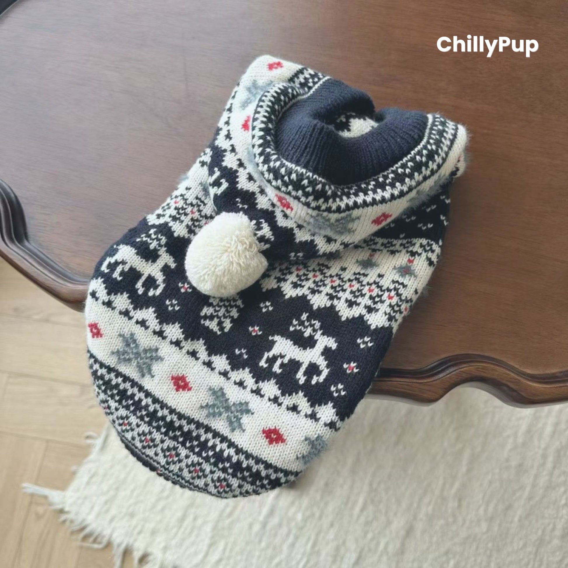 Knitted dog hoody with reindeer pattern on a wooden surface, branded 'ChillyPup'.