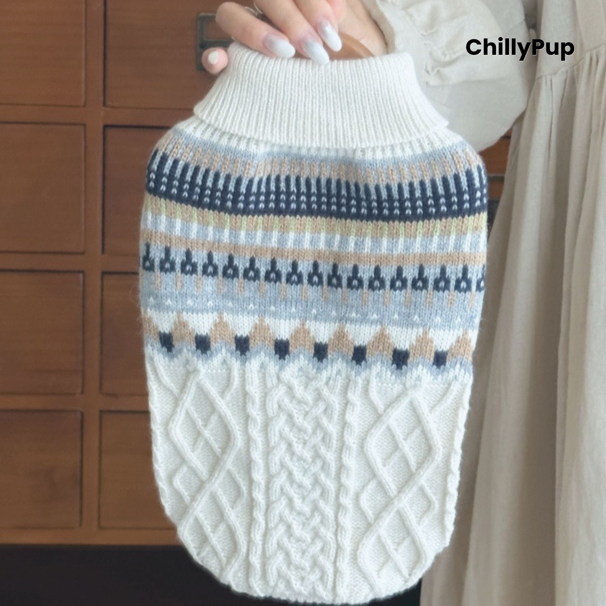 Knitted dog sweater with a pattern held by a person, brand 'ChillyPup' visible