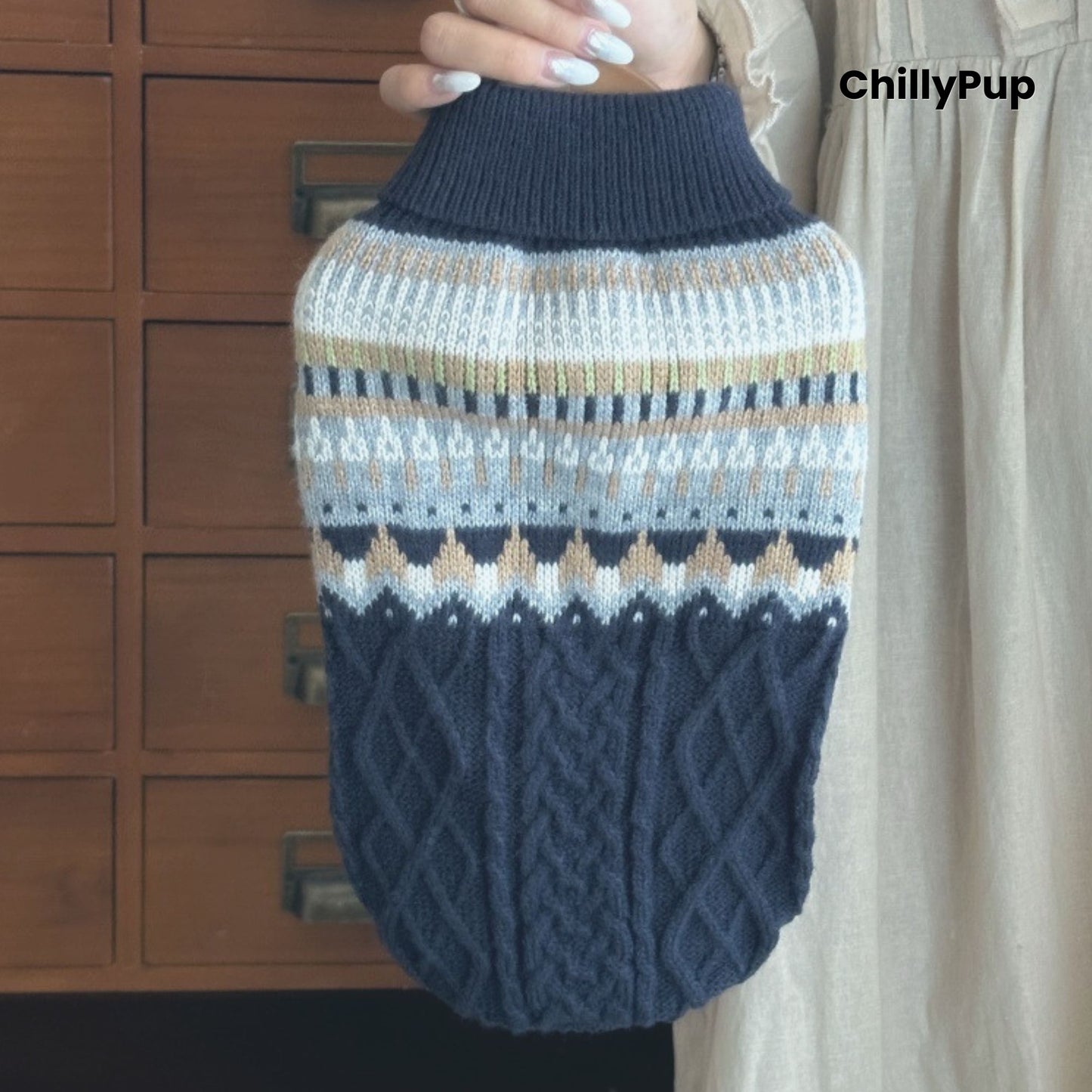 Knitted dog sweater with a pattern held by a person, brand 'ChillyPup' visible